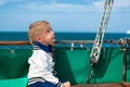 Funny little baby captain on board of sailing yacht