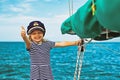 Funny little baby captain on board of sailing yacht