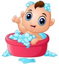 Funny little baby having bath with soap foam in a bathtub