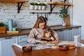 Funny little baby helper playing with dough on his hands learning to knead helps adult mom in the kitchen, happy cute baby Royalty Free Stock Photo