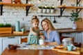 Funny little baby helper playing with dough on his hands learning to knead helps adult mom in the kitchen, happy cute baby Royalty Free Stock Photo