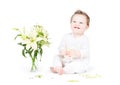 Funny little baby playing with lily flowers Royalty Free Stock Photo