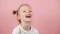 Funny little blonde girl smiling and lughing on pink background. Love and happy. Valentines Day or Mothers Day concept