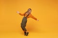 Funny little blonde kid girl 12-13 years old in turtleneck, jumpsuit isolated on orange yellow background. Childhood Royalty Free Stock Photo