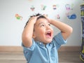 Funny little boy with freckles holding hair with hands