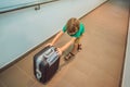 Funny little boy going on vacations trip with suitcase at airport, indoors