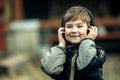 Funny little boy in headphones, outdoors. Happy. Royalty Free Stock Photo