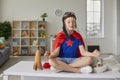 Funny little boy sitting on the table in the lotus position in the nursery. Royalty Free Stock Photo