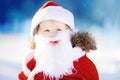 Funny little boy wearing Santa Claus costume in winter snowy park Royalty Free Stock Photo