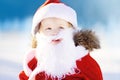 Funny little boy wearing Santa Claus costume in winter snowy park Royalty Free Stock Photo
