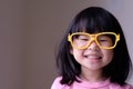 Funny little child with big yellow glasses