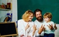 Funny little child with family having fun on blackboard background. Mother father and son together schooling. Happy