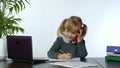 Funny little child girl boss manager emotionally talking on mobile phone, sitting at computer table Royalty Free Stock Photo