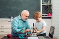 Funny little child having fun on blackboard background. Family generation and relations concept. A grandfather and a Royalty Free Stock Photo