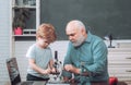 Funny little child having fun on blackboard background. Family generation and relations concept. A grandfather and a Royalty Free Stock Photo