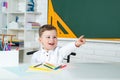 Funny little child having fun on blackboard background. School concept. Royalty Free Stock Photo