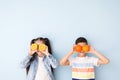 Funny little children with citrus fruit on color background