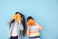 Funny little children with citrus fruit on color background