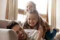 Funny little daughters playing with dad lying on his back Royalty Free Stock Photo