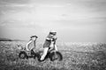 Funny little couple with vintage bike. Childhood memories. Happy children farmers cycle on spring field. Active children Royalty Free Stock Photo