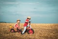 Funny little couple with vintage bike. Childhood memories. Happy children farmers cycle on spring field. Active children Royalty Free Stock Photo