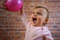 Funny little cute baby girl in pink with ball playing basketball Royalty Free Stock Photo