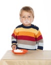 Dirty faced boy with cake in saucer, isolated on white