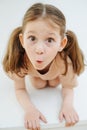 Funny little girl standing on all fours, grimacing over white backgound Royalty Free Stock Photo