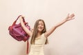 Funny little girl with big backpack jumping and having fun against white wall. School concept. Back to School. School& x27;s out Royalty Free Stock Photo