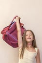 Funny little girl with big backpack jumping and having fun against white wall. School concept. Back to School. School& x27;s out Royalty Free Stock Photo