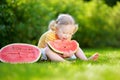 Funny little girl biting a slice of watermelon outdoors Royalty Free Stock Photo