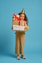 Funny little girl in cap holds birthday gift box Royalty Free Stock Photo