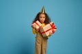 Funny little girl in cap holds birthday gift box Royalty Free Stock Photo