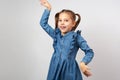 Funny little girl dancing with raised hands against white background Royalty Free Stock Photo