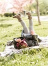 Funny little girl doing exerciseson a plaid in the park Royalty Free Stock Photo