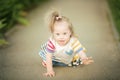 Funny little girl with Down syndrome creeps along the path Royalty Free Stock Photo