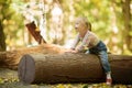 Funny little girl with Down syndrome sitting on a large log