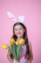 Funny little girl with easter bunny ears holding a bouquet of spring flowers Royalty Free Stock Photo