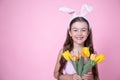 Funny little girl with easter bunny ears holding a bouquet of spring flowers copy space Royalty Free Stock Photo