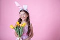 Funny little girl with easter bunny ears holding a bouquet of spring flowers copy space Royalty Free Stock Photo