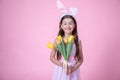 Funny little girl with easter bunny ears holding a bouquet of spring flowers copy space Royalty Free Stock Photo