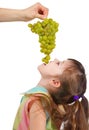 Funny little girl eating grapes from hand Royalty Free Stock Photo