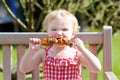 Funny little girl eating grilled meat from spoon