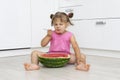 Funny little girl eating watermelon with a big spoon Royalty Free Stock Photo