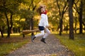 Funny little girl flies on broom in autumn