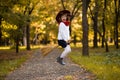 Funny little girl flies on broom in autumn