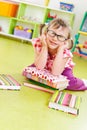 Funny little girl with books on floor Royalty Free Stock Photo