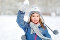 Funny little girl having fun in beautiful winter park during snowfall Royalty Free Stock Photo