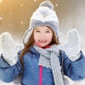 Funny little girl having fun in beautiful winter park during snowfall Royalty Free Stock Photo