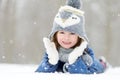 Funny little girl having fun in beautiful winter park during snowfall Royalty Free Stock Photo